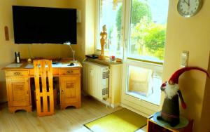 um quarto com uma secretária, uma televisão e uma janela em Sonnengruss am Strand em Eckernförde