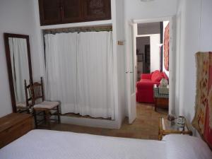 a bedroom with a bed and a red couch at Casa Sol in Vejer de la Frontera