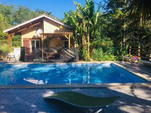 a swimming pool in front of a house at Gîte Le Bellevue avec piscine privative - climatisation in Dolmayrac