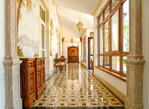 a hallway with a checkered floor and windows at Sintra Marmoris Palace in Sintra