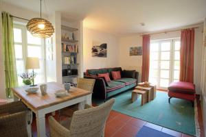 a living room with a couch and a table at Strand-Appartement "Sanddornstübchen" in Dranske +23 photos