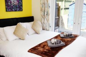 Una cama con toallas y almohadas encima. en 7SM Dreams Unlimited Serviced Accommodation- Stanwell-Staines-Heathrow en Stanwell