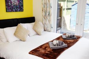 un letto con asciugamani e cuscini sopra di 7SM Dreams Unlimited Serviced Accommodation- Stanwell-Staines-Heathrow a Stanwell