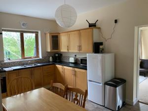 a kitchen with a table and a white refrigerator at Secluded hilltop hideaway! in Westport