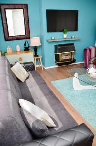 un soggiorno con divano e TV di 7SM Dreams Unlimited Serviced Accommodation- Stanwell-Staines-Heathrow a Stanwell