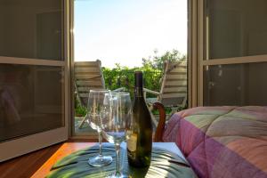 a bottle of wine and two glasses on a table at Panorami sul Trasimeno in San Feliciano