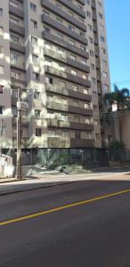 una calle vacía delante de un edificio alto en Apartamento central, novo e com garagem em Curitiba, en Curitiba