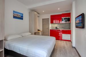 a bedroom with a white bed and red cabinets at Appartements French Riviera Confidential Centre Ville Juan les Pins proche des plages in Juan-les-Pins +20 photos