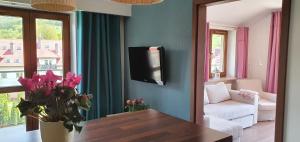 - un salon avec un canapé et une télévision murale dans l'établissement Apartament Jaworzyna, à Krynica-Zdrój