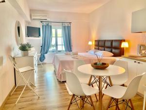a bedroom with a bed and a table and chairs at Agios Ioannis luxurious beachfront studio in Agios Ioannis Pelio