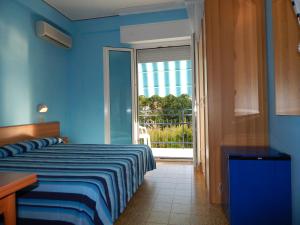 um quarto azul com uma cama e uma porta de vidro deslizante em Hotel Vera em Riccione