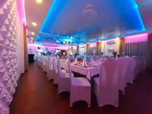 a banquet hall with white tables and white chairs at Route One - Restauracja & Pokoje Hotelowe in Zgierz