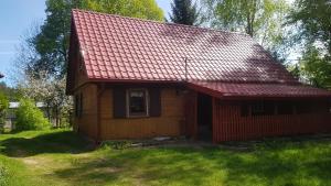 a small wooden house with a red roof at Zacisze in Kukle +14 photos
