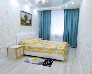 Schlafzimmer mit einem Bett mit gelber und blauer Decke in der Unterkunft Apartment in the center of Bender in Bender