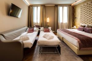um quarto de hotel com duas camas e um sofá em BW Premier Collection CHC Continental em Veneza