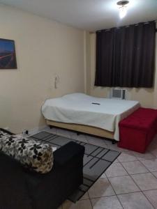sypialnia z łóżkiem, kanapą i oknem w obiekcie Apto no Centro w mieście Campos dos Goytacazes