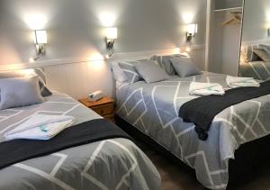 Duas camas sentadas uma ao lado da outra num quarto em Ulladulla Motel em Ulladulla