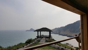 einen Pavillon auf einem Hügel neben dem Meer in der Unterkunft Dapu Inn in Juguang