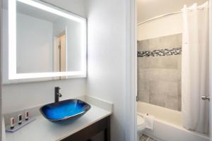 a bathroom with a blue sink and a tub at Clarion Pointe in Charlotte +16 photos