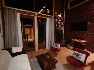 The Loft في لاس ترانكاس: غرفة معيشة بها أريكة وكراسي وتلفزيون