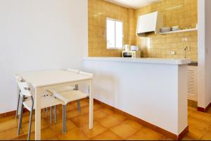 eine Küche mit einem Tisch und Stühlen im Zimmer in der Unterkunft One bedroom apartement with sea view shared pool and furnished balcony at Sant Josep de sa Talaia in San Jose de sa Talaia