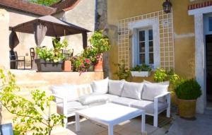 ル・ブランにあるMaison de 3 chambres avec jacuzzi jardin clos et wifi a Le Blancの白いソファとテーブル付きのパティオ