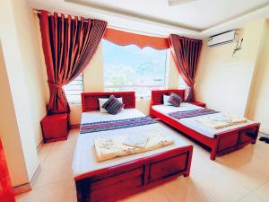 two beds in a room with a window at The Ha Giang Loop Hostel in Ha Giang