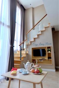 een woonkamer met een tafel en een trap bij Maysa BY M in Hua Hin