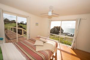 a bedroom with a bed with a view of the ocean at Ashendens at Penneshaw in Penneshaw