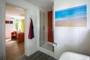 uma casa de banho com um chuveiro e um lavatório. em Villa Sanssouci - Bäderstilvilla mit individuellen Wohnungen em Binz