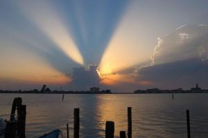 Una puesta de sol con una nube en el cielo sobre el agua. en Casa alla Torre, en Chioggia 4 fotos más
