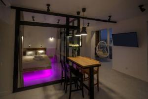 a bedroom with a bed and a table with purple lights at Cozy39 in Kaliningrad