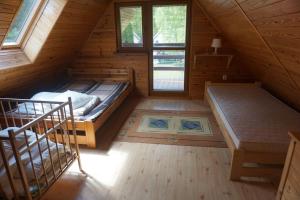 a room with two beds in a wooden cabin at Osada Sosnowa in Kopalino