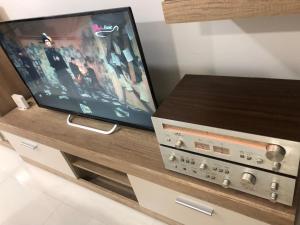 a flat screen tv sitting on top of a entertainment center at Apartment on a river avenue in Pančevo