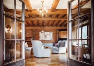 a living room with wooden ceilings and a chandelier at Chalet Alpenglück in Reith im Alpbachtal