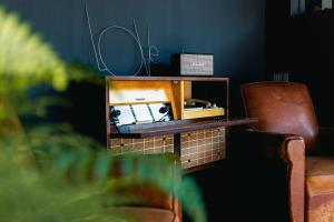 a living room with a table and a chair at Bateau Libre Hotel in Bénodet