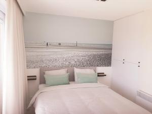een slaapkamer met een bed en uitzicht op het strand bij Léonie met parking in Nieuwpoort