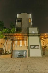 a large white building with a garage at night at Urbanest Inn House Slipi in Jakarta