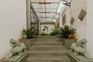 a staircase with two lion statues in a building at Urbanest Inn House Slipi in Jakarta