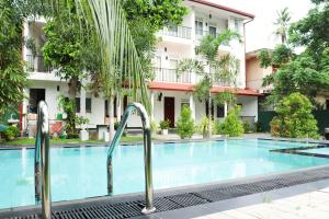 a swimming pool in front of a building at Ritz Gate Kalutara in Kalutara