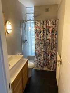 a bathroom with a shower curtain and a toilet at Sea Views Penthouse in Sitges