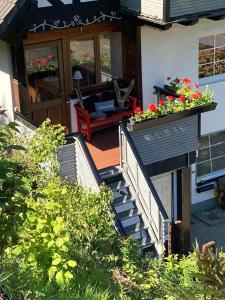 a house with a staircase with flowers on it at Ferienwohnung Dünnebacke in Schmallenberg