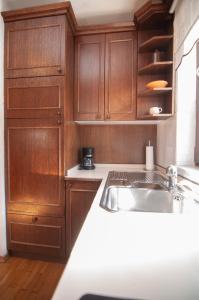 una cucina con armadi in legno e lavandino di Guest house Vila Korošec a Bovec