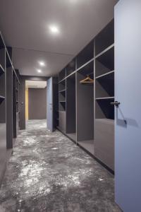 a walk in closet with black cabinets and a concrete floor at Mamaison Residence Diana in Warsaw