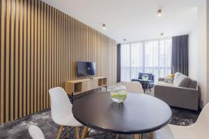 a living room with a table and chairs and a couch at Mamaison Residence Diana in Warsaw