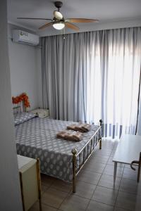 sypialnia z 2 łóżkami i wentylatorem sufitowym w obiekcie Alkyon Perea Apartments w mieście Perea