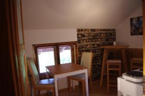 een keuken met een tafel en stoelen en een bakstenen muur bij Bed and Breakfast Lucia in Pfronten