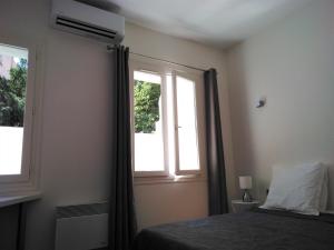 - une chambre avec un lit et 2 fenêtres dans l'établissement APPART AIX MAZARIN, à Aix-en-Provence