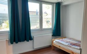 a bedroom with blue curtains and a bed and a window at Workers House in zentraler, ruhiger Umgebung in Wernau