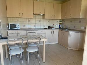 a kitchen with a table and chairs and a microwave at Uytno in Chornomorsk